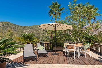 A deck with a table and chairs and an umbrella