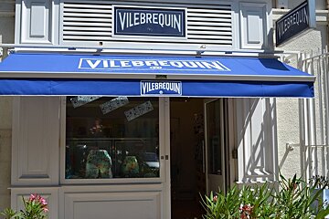 image of the Vilebrequin shop front with a blue canopy, white shop front and white writing
