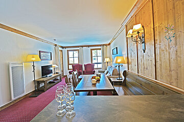 A living room with a table and chairs and a television