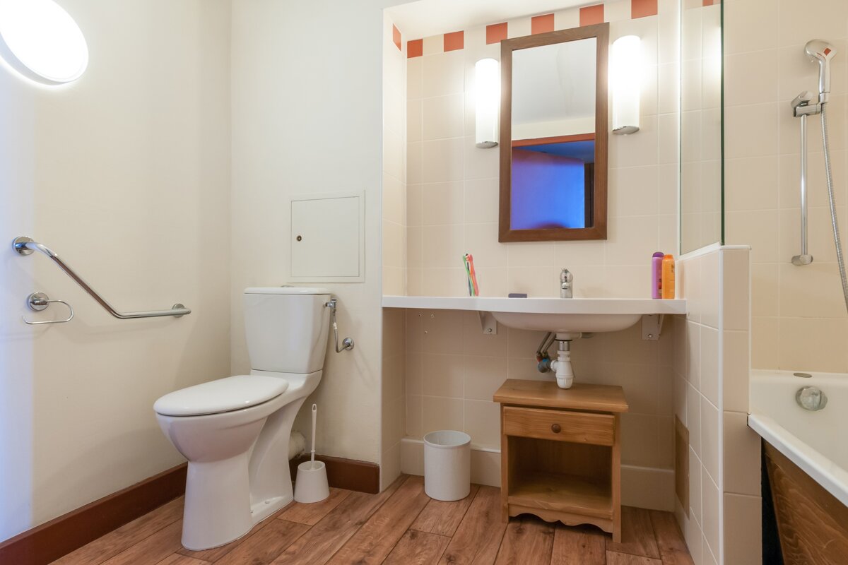 A bathroom with a toilet a sink and a mirror