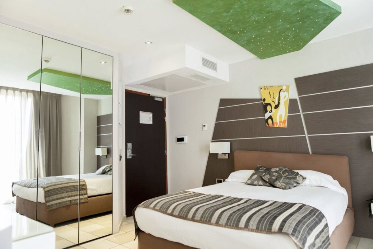 A hotel room with a bed and a painting on the wall