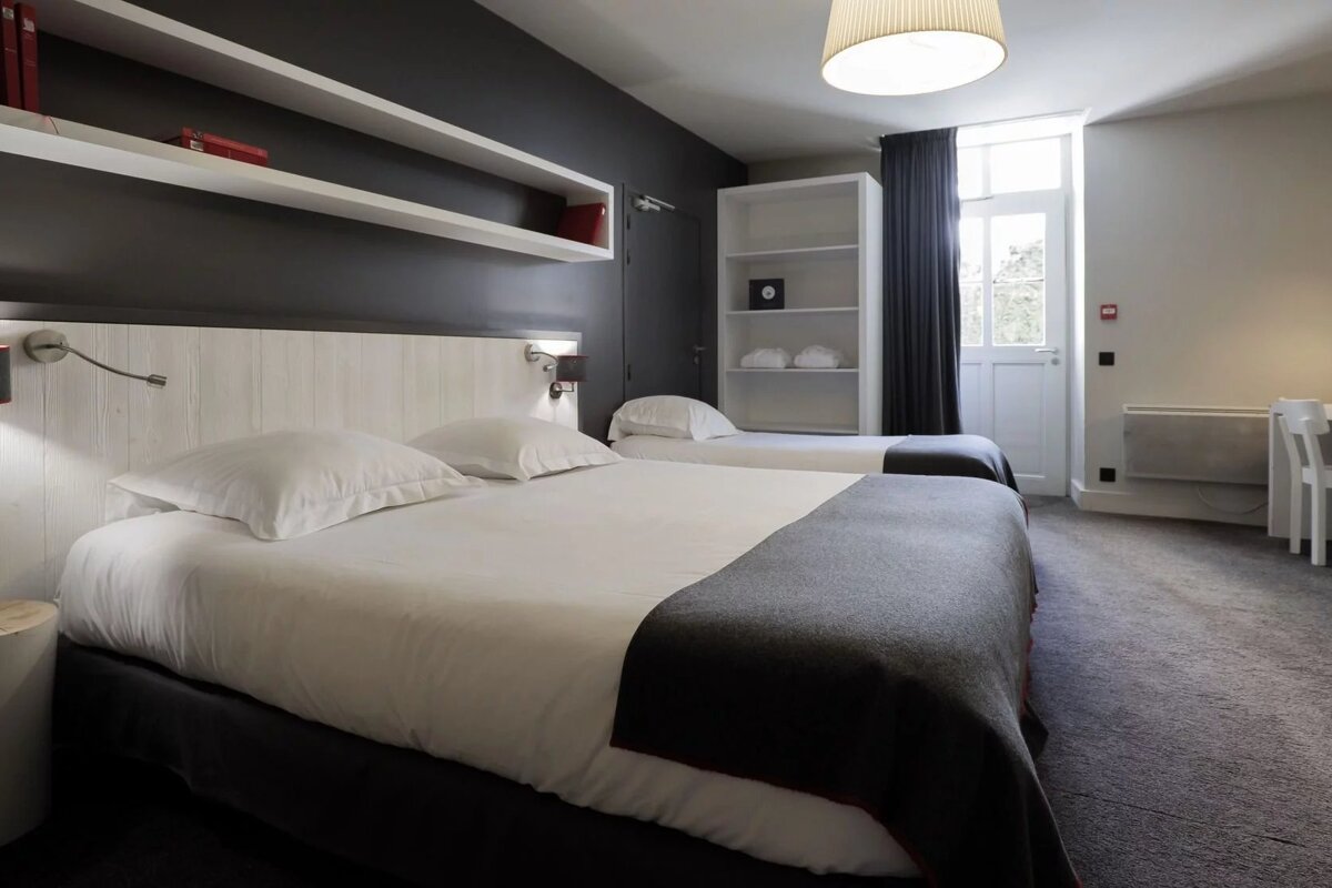 A hotel room with two beds and a fire extinguisher