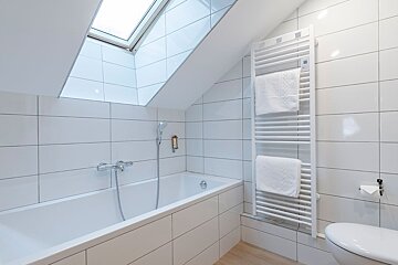 A bathroom with a bathtub and a towel rack