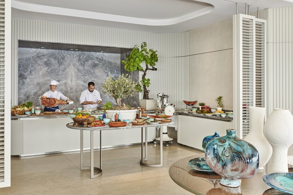 Two chefs are preparing food in a buffet area