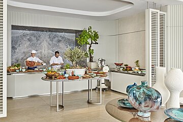 Two chefs are preparing food in a buffet area
