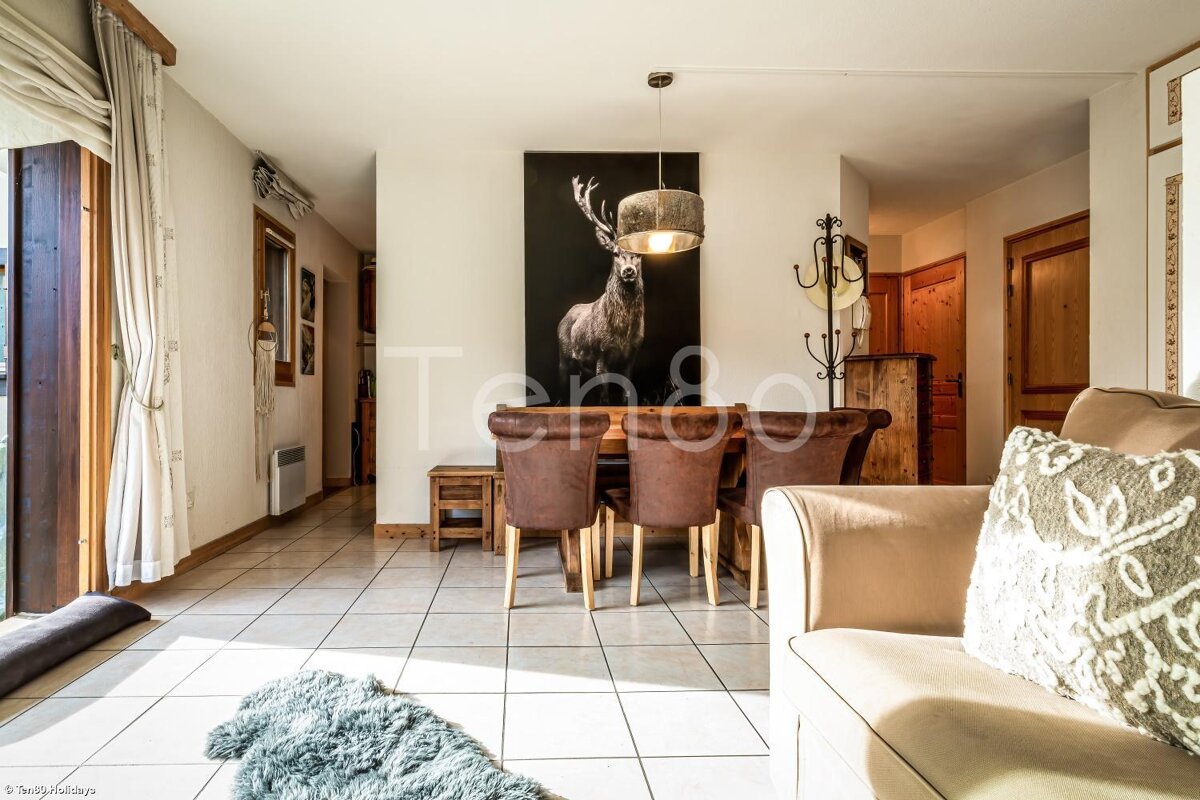 A picture of a deer hangs above a dining table