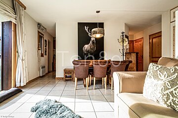 A picture of a deer hangs above a dining table