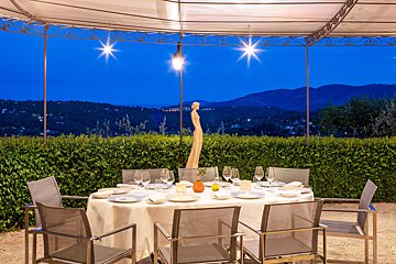 A table and chairs under a canopy with mountains in the background