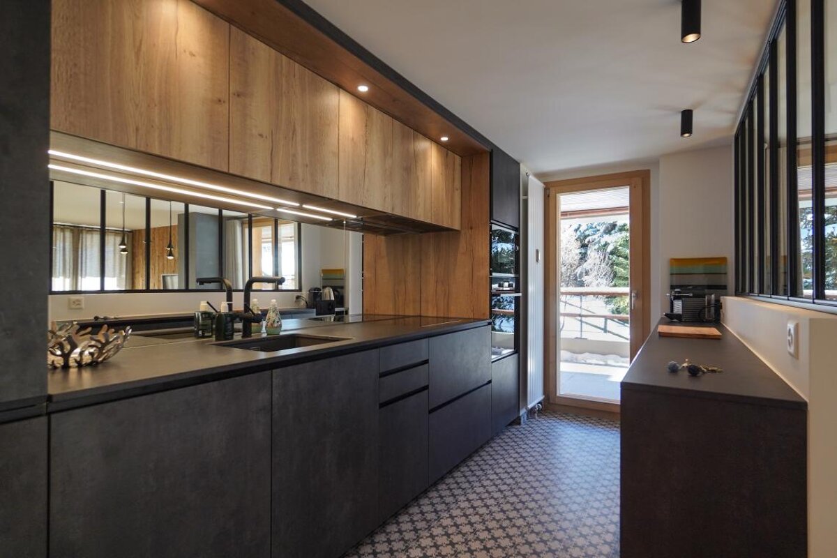 A kitchen with black cabinets and wooden cabinets