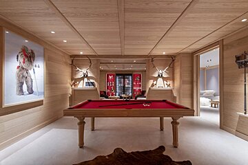 A pool table in a room with a painting on the wall