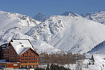 A snowy mountain with a hotel in the foreground