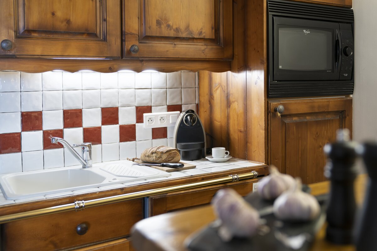A whirlpool microwave sits above a sink in a kitchen