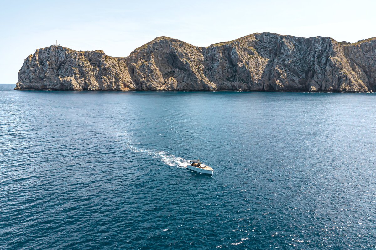 A boat in the ocean with a mountain in the background