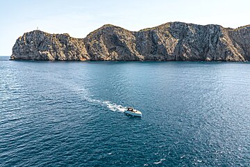 A boat in the ocean with a mountain in the background