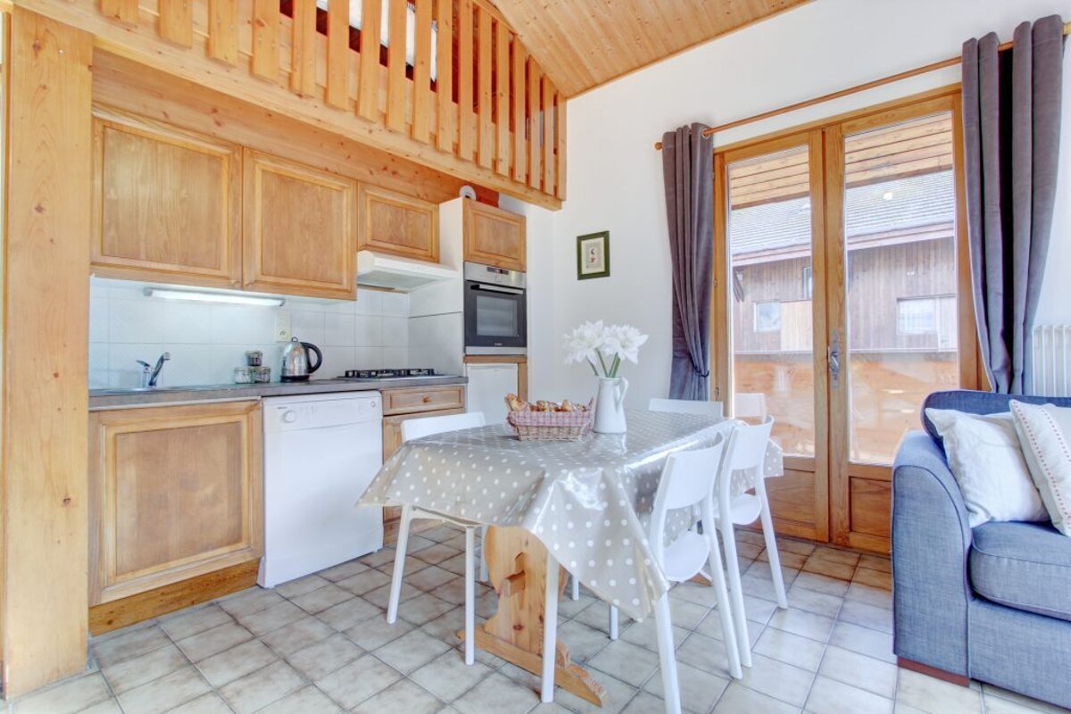 A kitchen with a table and chairs in it