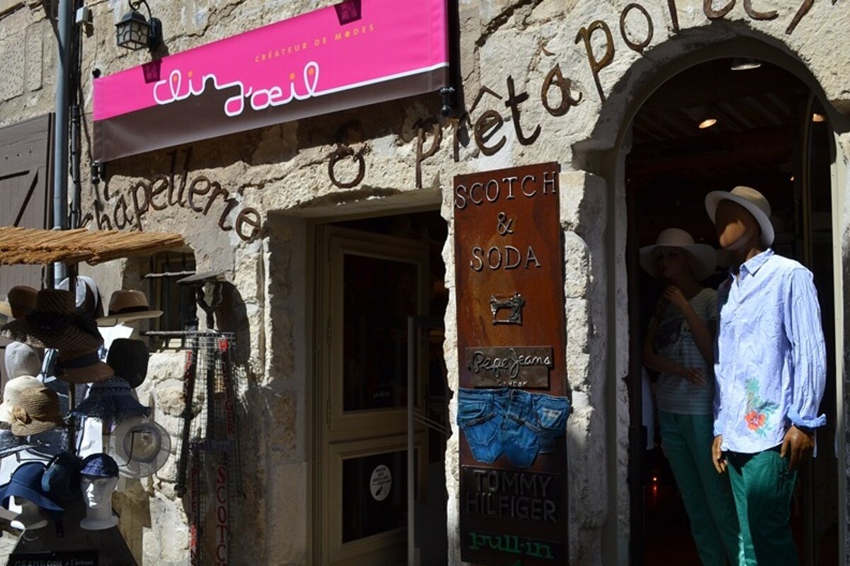 image of the Clin d'oeil shop front with mannequins and a hat display out front. 