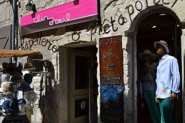 image of the Clin d'oeil shop front with mannequins and a hat display out front. 