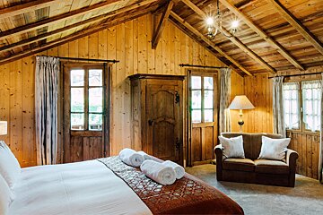 A wooden room with a bed and a couch