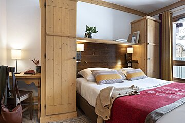 A bedroom with a large bed and a wooden headboard