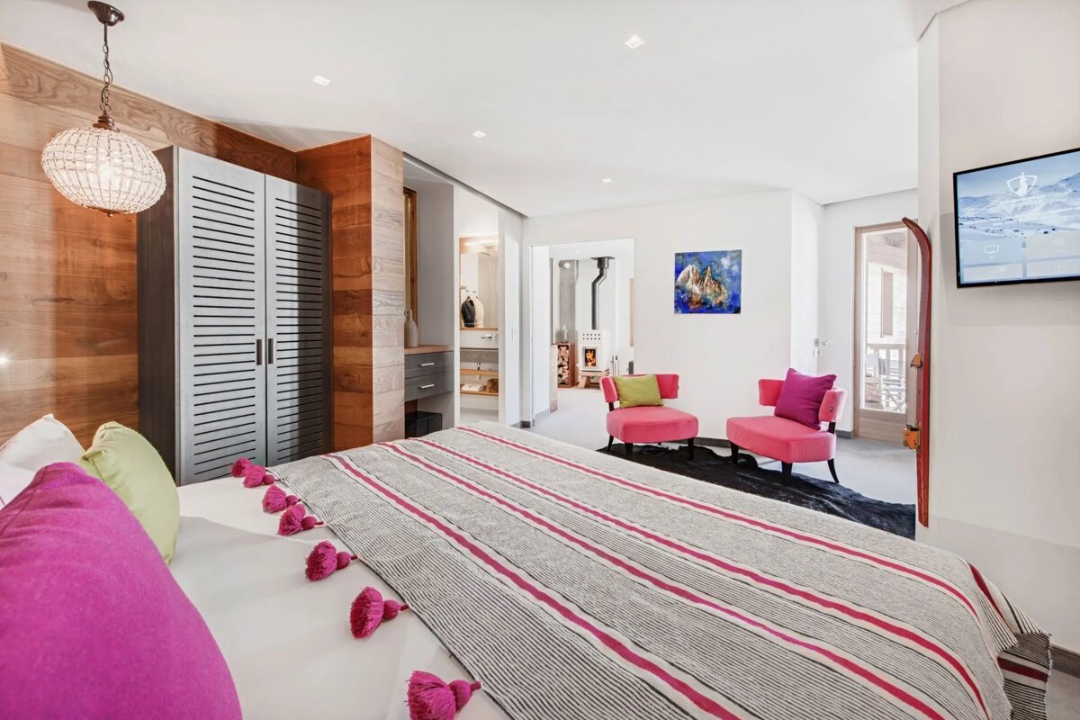 A bedroom with a large bed and a flat screen tv