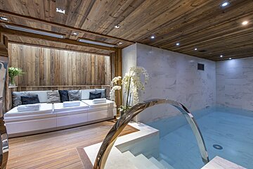 A swimming pool with a wooden ceiling and white tiles