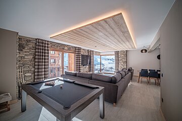 A living room with a pool table and a couch