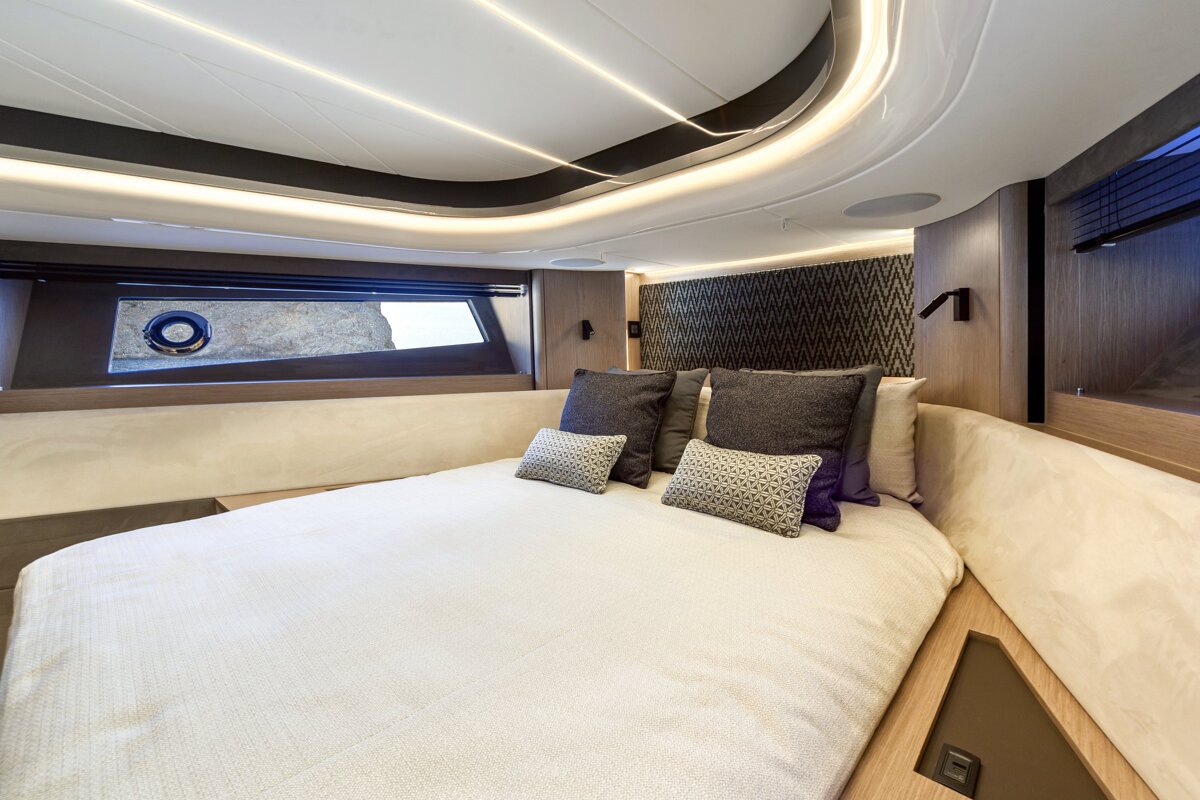 A bedroom with a bed and pillows and a window