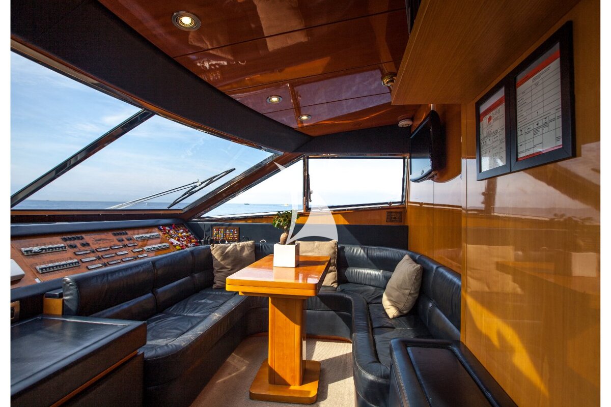 A boat with a couch and a table in front of a control panel