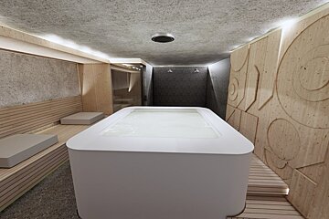 A white bathtub in a room with wooden walls