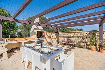 A patio with a table and chairs under a pergola