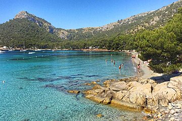 people swimming in the sea at a beach in mallorca