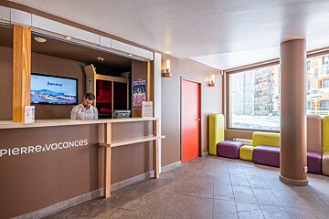 A man stands behind a counter that says pierre & vacances