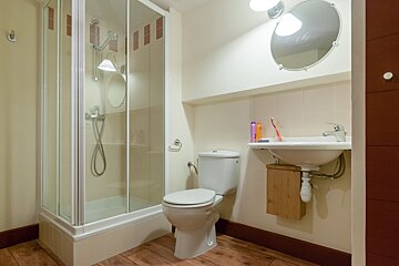 A bathroom with a toilet a sink and a shower