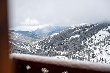 A view of a snowy mountain range from a balcony