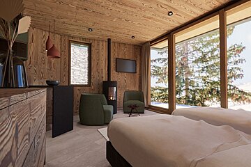 A cozy, wood-paneled room with a fireplace, TV, armchairs, and a large window offering a scenic view of snowy mountains and pine trees.