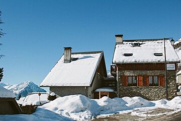 A snow covered building with a sign that says ' altitude ' on it