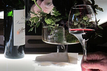 A bottle of chateau diana sits next to a glass of wine