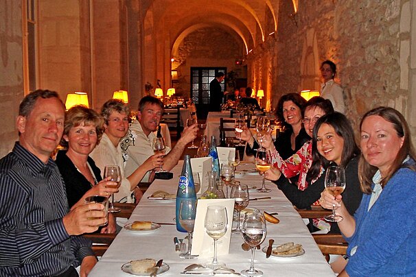 a picture of a table of people raising a glass at dinner