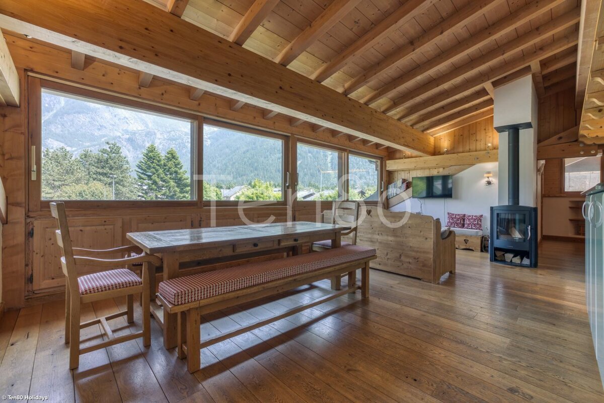 A living room with a table and chairs and a fireplace