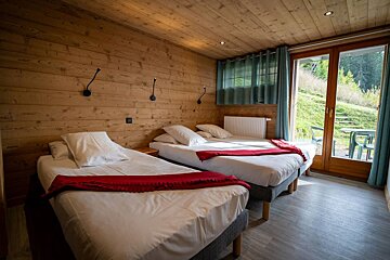 A bedroom with two beds and a large window
