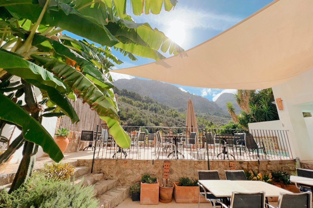 A patio with tables and chairs and mountains in the background