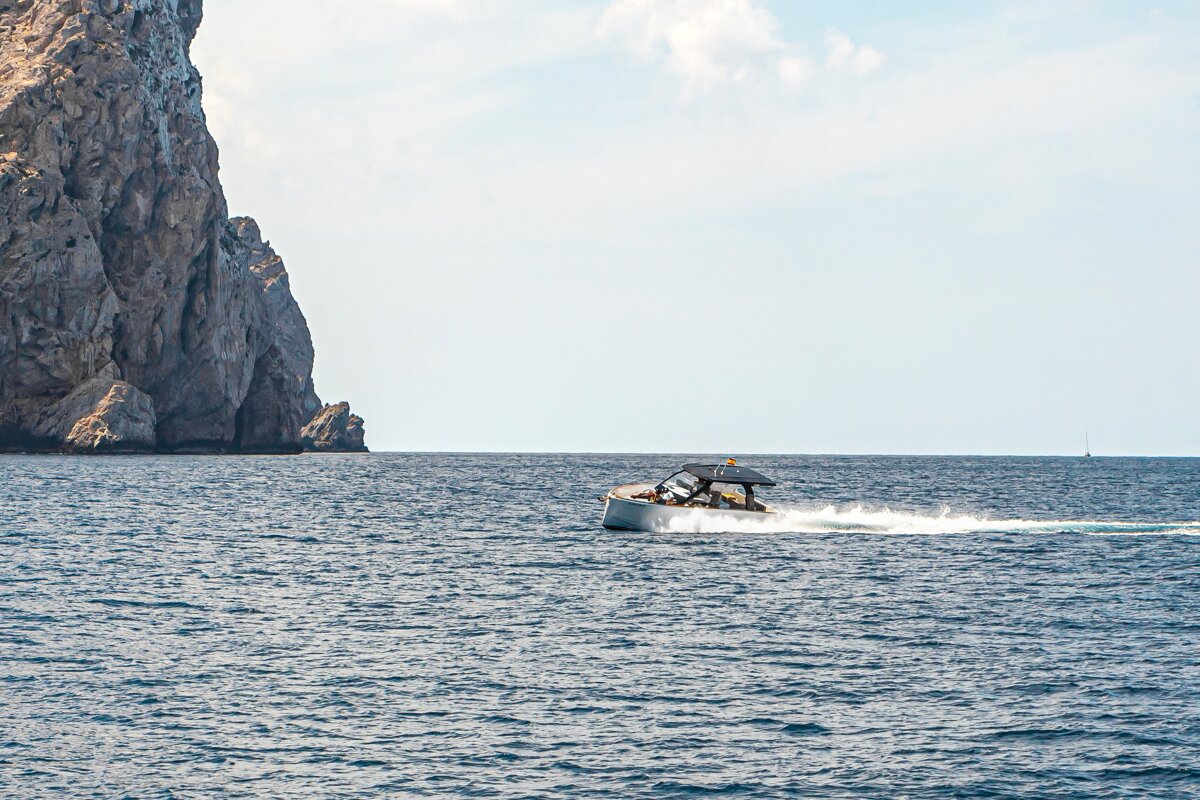 A boat in the ocean with a mountain in the background
