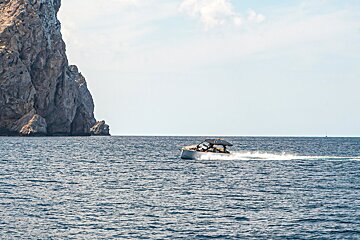 A boat in the ocean with a mountain in the background
