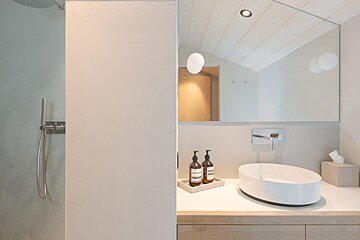 A bathroom with a sink and two bottles of aesop