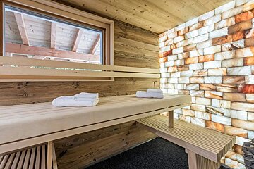 A wooden bench in a sauna with towels on it