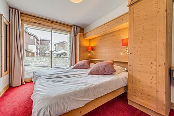 A bedroom with two beds and a sliding glass door