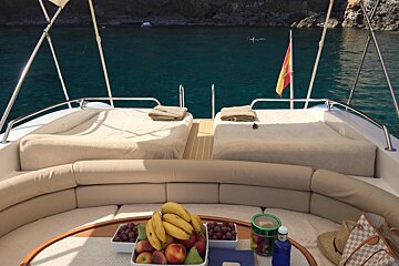 A bowl of fruit sits on a table on the back of a boat