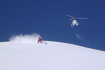 a helicopter above a skier off piste