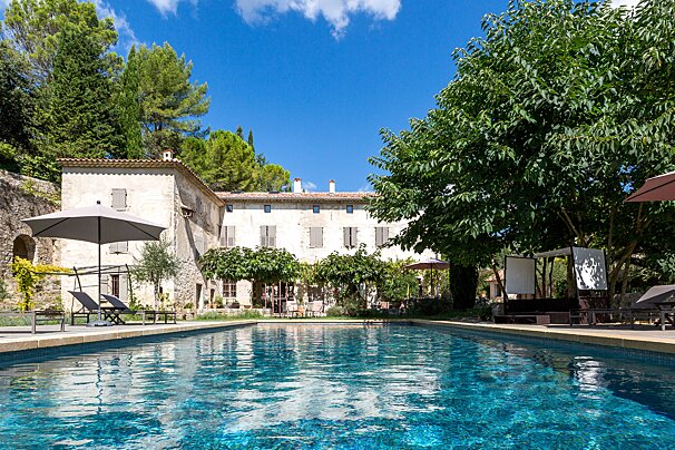 A large swimming pool in front of a large house