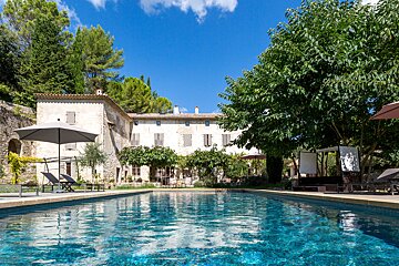 A large swimming pool in front of a large house